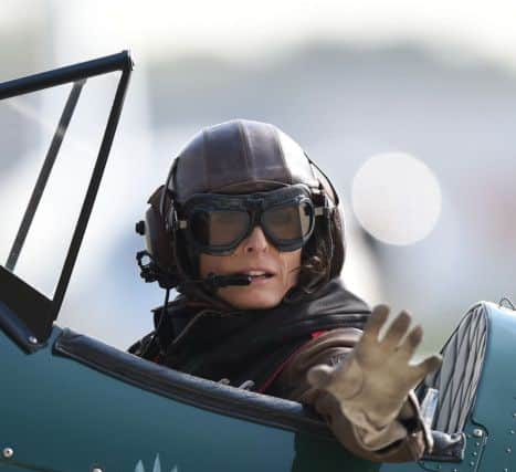 Tracey Curtis-Taylor waving to onlookers from the cockpit of her 1942 Boeing Stearman Spirit of Artemis biplane.