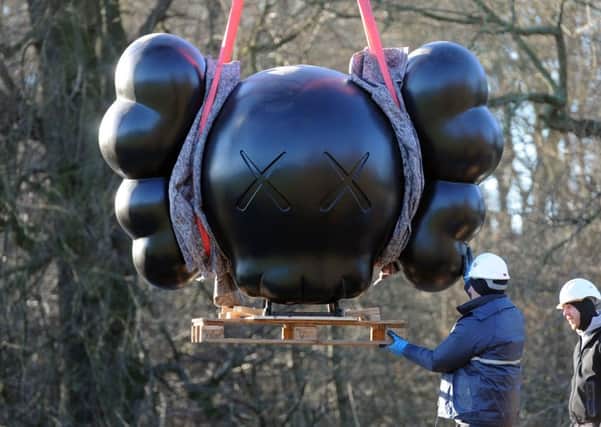 Sculpture technicians install six enormous sculptures by renowned American artist KAWS  some measuring up to ten-metres tall  at Yorkshire Sculpture Park. Picture Tony Johnson