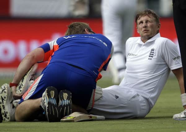 England's Joe Root is assisted by team physiotherapist on the second day in Johannesburg. Pictrure: AP/Themba Hadebe.