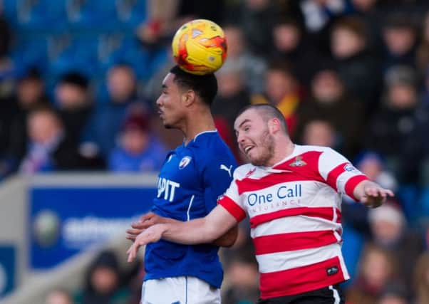 Doncaster Rovers' Luke McCullough challenges Chesterfield's Byron Harrison (Picture: James Williamson).