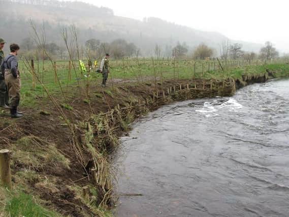 Dan Turner, left, of the Yorkshire Dales River Trust after successfully completing 'willow spiling' at  a river.