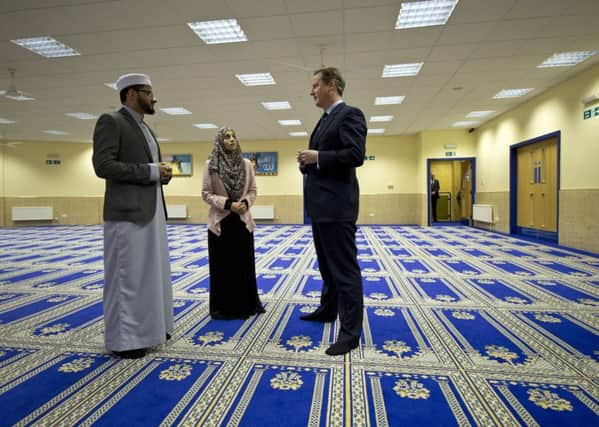 Prime Minister David Cameron talks to Imam Qari Asim (left), and Shabana Muneer, a member of Makkah Masjid Mosque's women's group, during a visit to the Makkah Masjid Mosque in Leeds. (Picture: Oli Scarff/PA Wire)