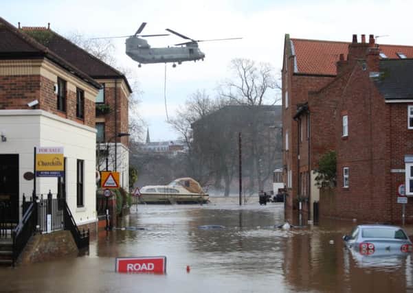 A Chinook helicopter delivers materials to repair York's flood barrier.