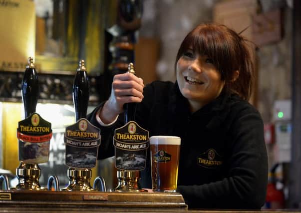 Katie Ross pulling a pint of Noah's Ark Ale at Theakston Brewery at Masham
