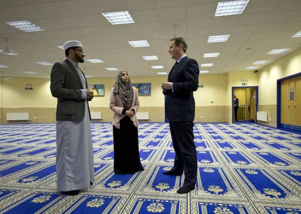 Prime Minister David Cameron talks to imam Qari Asim (left), and Shabana Muneer, a member of Makkah Masjid Mosque's women's group, during a visit to the  Makkah Masjid Mosque in Leeds, as he has warned that Muslim women who fail to improve their English language skills could be deported as part of a drive to build community integration and counter extremism.  Photo: Oli Scarff/PA Wire