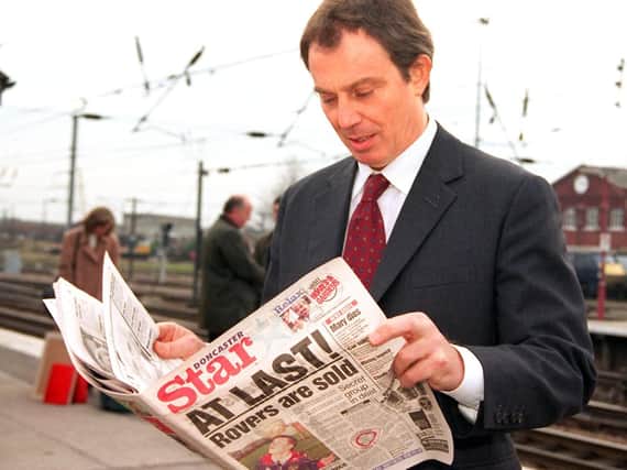 Prime Minister Tony Blair catches up with the news in Doncaster as he changes trains at the station in 1998.
