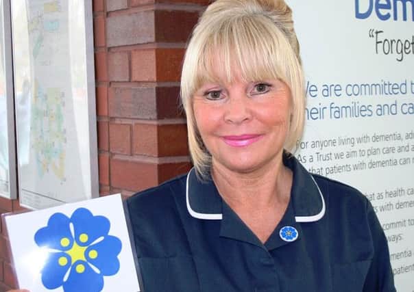 Senior Sister Anita Ruckledge with the Forget Me Not Flower.
The quality of care for dementia patients is set to improve with the help of a small 
blue flower.
The Mid Yorkshire Hospitals NHS Trusts Forget-Me-Not scheme aims to provide 

better services for people with the condition at its hospitals in Pinderfields, Pontefract and Dewsbury and reassure their loved ones that they are receiving the best possible care.