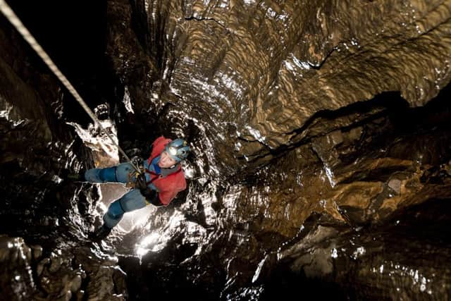 A caver abseils down a vertical shaft, often the only way to access the cave systems beneath Lancaster Hole.