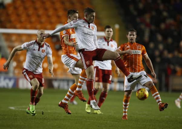 Paul Coutts of Sheffield Utd gets in front of Blackpool's Will Almson.