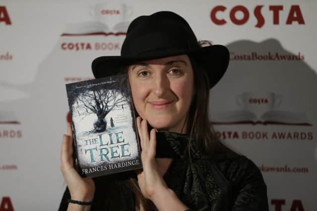 The winner of the childrens book category Frances Hardinge poses for photographs with her book The Lie Tree at the Costa Book Awards in London, Tuesday, Jan. 26, 2016.  (AP Photo/Matt Dunham)