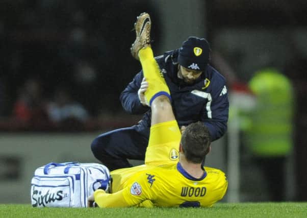 Leeds United's Chris Wood is treated for a hamstring injury at Brentford.