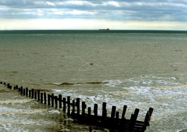 The North sea  splashes around one of the old groynes alongside Spurn Point as a tanker is seen on the horizon.
Picture: Gary Longbottom