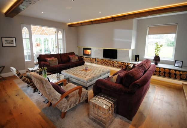 The sitting room, which Simon designed . The chimney breast and alcove were boxed in and wrapped in grey granite with a matching log storage bench and a wood burning fire.