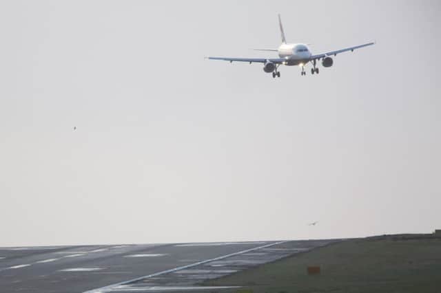 Birds fly across the runway as a plane lands in high wind at Leeds Bradford Airport. Picture: Ross Parry Agency