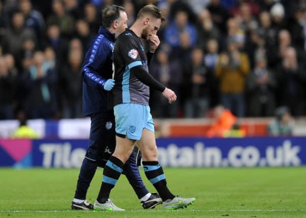 Tom Lees leaves the field injured with physio Paul Smith during the Capital One Cup quarter-final defeat to Stoke in December.