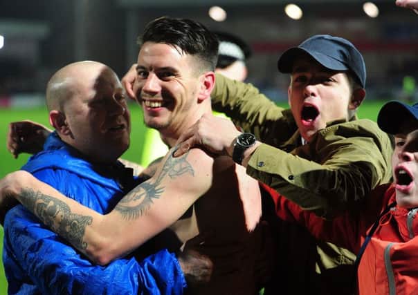 Adam Hammill is hugged by Barnsley fans after clinching the clubs place at Wembley (Picture: Jonathan Gawthorpe).