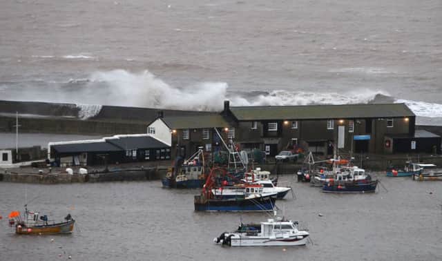 Waves crash against the harbour wall in Lyme Regis, Dorset as winds of nearly 100mph battered Britain
