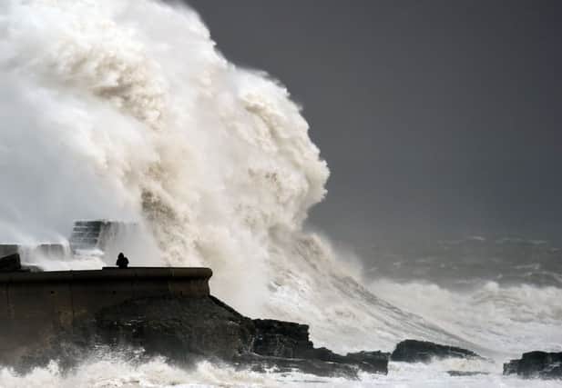 Waves crash over the sea wall at Porthcawl in Wales as winds of nearly 100mph battered Britain after Storm Imogen slammed into the south coast