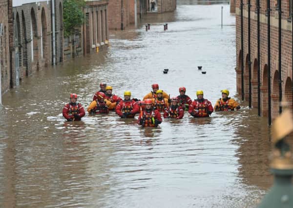 Members of the Mountain Rescue teams wade through floodwater in Skeldergate, York.