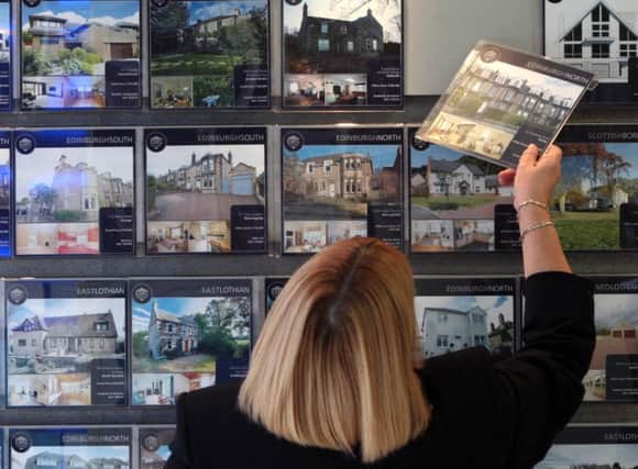 A library image of a woman looking at houses for sale Photo: David Cheskin/PA Wire