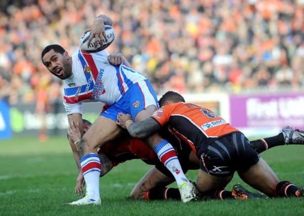 Wakefield's Bill Tupou is held by the Castleford tacklers.