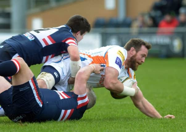 Dean Schofield of Yorkshire Carnegie  is caught in a double tackle from Doncaster Knights.