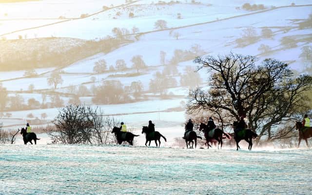 Snow-covered hills across Coverdale in the Yorkshire Dales as horses and their riders make their way to the gallops on Middleham Moor following overnight snowfall. John Giles/PA Wire