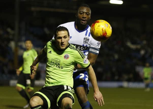 United's Billy Sharp under pressure from Nathan Cameron of Bury.