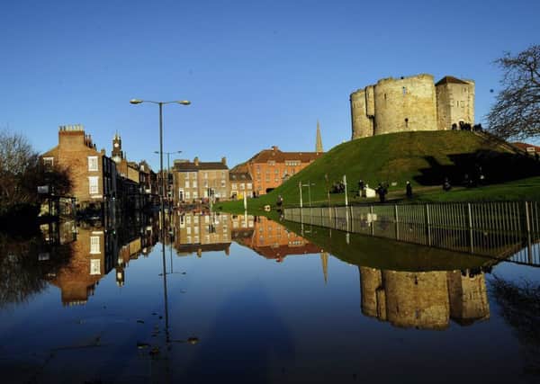 Clifford's Tower, once part of York Castle, in York, which sits between the River Ouse and River Foss, is reflected in floodwater after the rivers burst their banks.