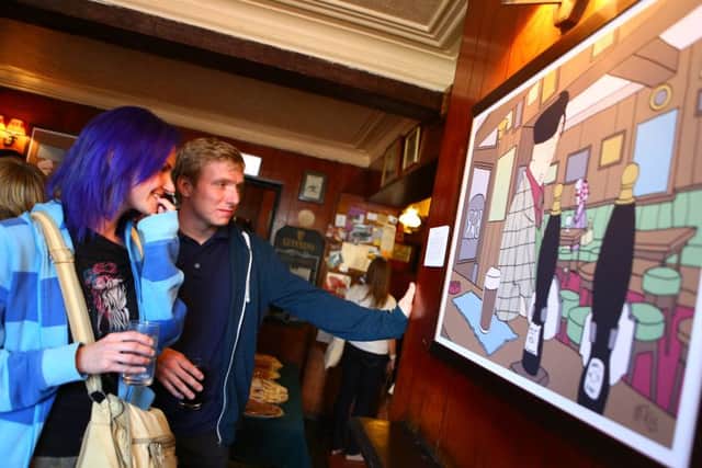 Pub Scrawl is one of the many arts events in the city. Pictured are visitors examining a piece by city artist Pete McKee.
Picture: Ian Spooner.