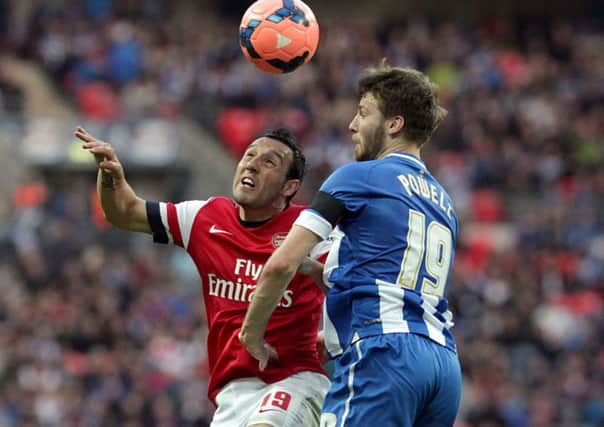 Nick Powell, then with Wigan Athletic on loan, and Arsenal's Santi Cazorla battle for the ball.