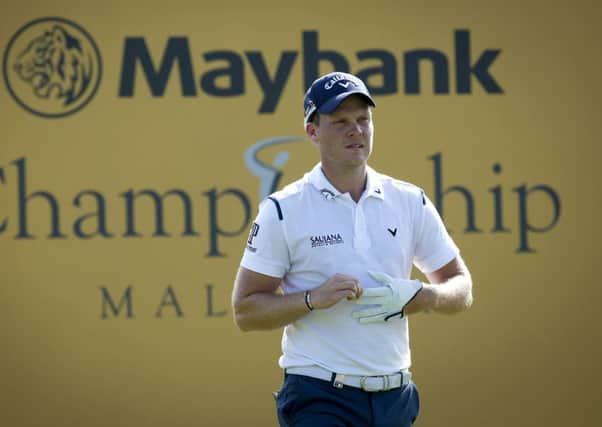 Danny Willett of Britain takes off his glove after hitting a shot during day two of the Maybank Championship golf tournament in Kuala Lumpur, Malaysia. (AP Photo/Vincent Thian)