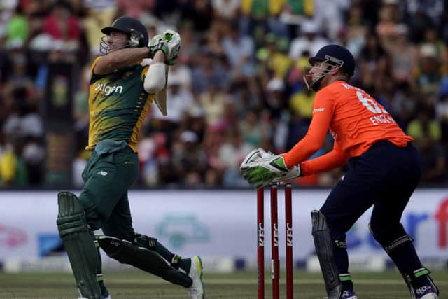 South Africas batsman AB de Villiers, left, watches his shot as Englands wicketkeeper Jos Buttler, right, looks on during the second and the final T20 cricket match between South Africa and England at the Wanderers Stadium in Johannesburg, South Africa, Sunday, Feb. 21, 2016. (AP Photo/Themba Hadebe)