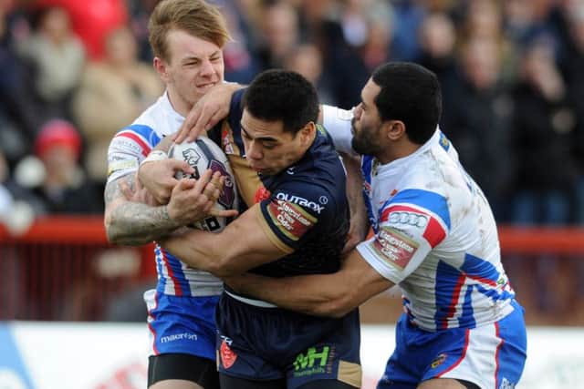 Hull Kingston Rovers Ken Sio holds onto the ball as he is tackled by Wakefield duo Tom Johnstone and Bill Tupou.