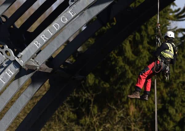 A surveyor abseils off the Iron Bridge over the River Severn in Shropshire. Picture: Joe Giddens/PA Wire