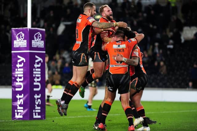 Castleford's players mob Denny Solomona after he scored his hat-trick try late on against Hull FC.
 Picture: Jonathan Gawthorpe