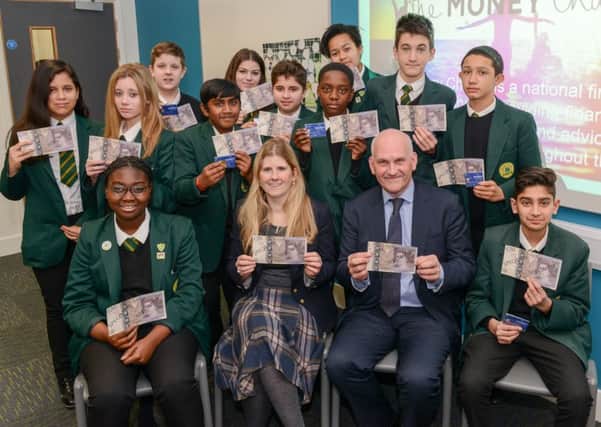 Andrew Jones, chief executive at HML, Michelle Highman, chief executive at The Money Charity, and pupils after a recent money awareness class.