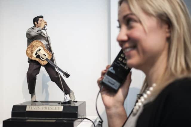 A Sotheby's employee holds an Elvis Presley telephone which will be auctioned. Picture: Lauren Hurley/PA Wire
