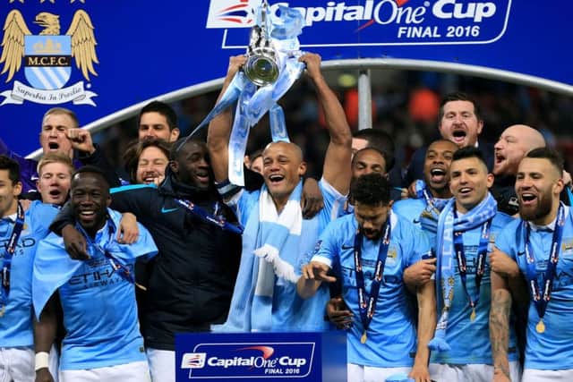 Manchester City's Vincent Kompany (centre) and team-mates celebrate with the trophy after victory in the Capital One Cup final at Wembley.