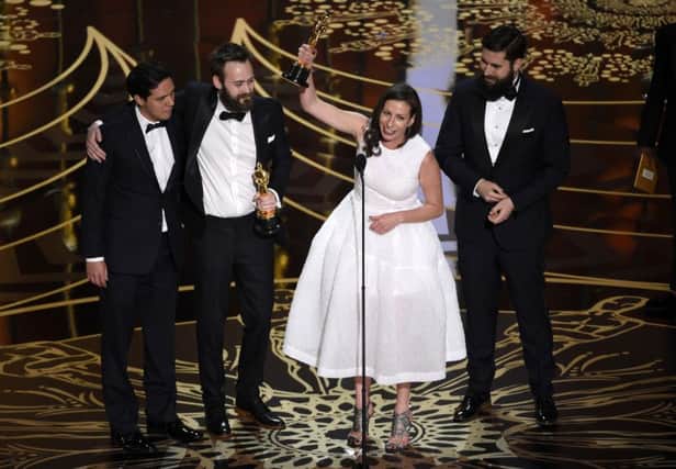 From left, Benjamin Cleary, Serena Armitage, and Michael Paleodimos accept the award for best live action short film for Stutterer at the Oscars