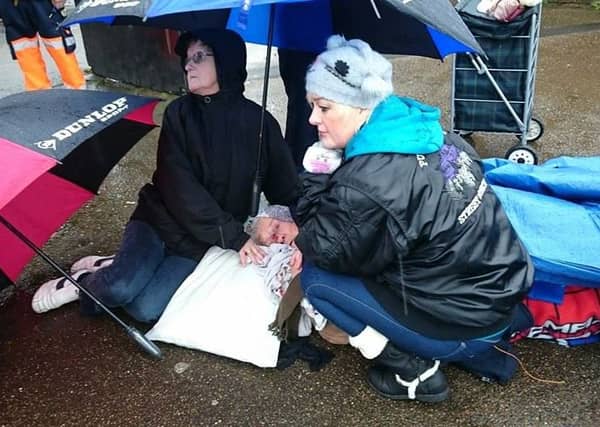 Market traders help Doreen Gibson, 89, who had to wait nearly three hours for an ambulance after a fall