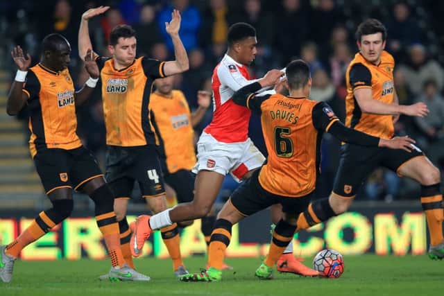 Arsenal's Alex Iwobi and Hull City's Curtis Davies battle for the ball during the FA Cup, fifth round replay match at the KC Stadium, Hull.