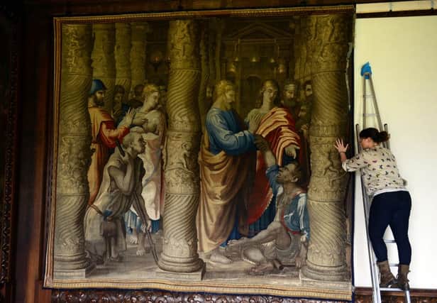 Staff member Amy Secker re-installs one of the 16th century Mortlake Tapestries in the State Drawing Room at Chatsworth