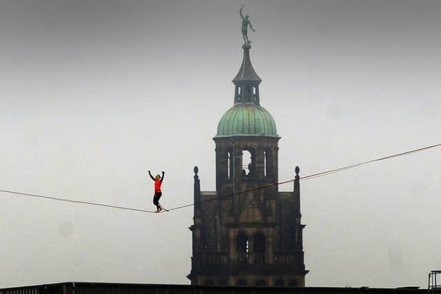 High wire walker Sarah Rixham walks the line with Sheffield Town Hall as a backdrop. Picture by Simon Hulme