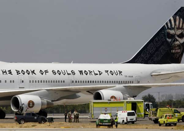 Local police stand beside the aircraft of English heavy metal band Iron Maiden