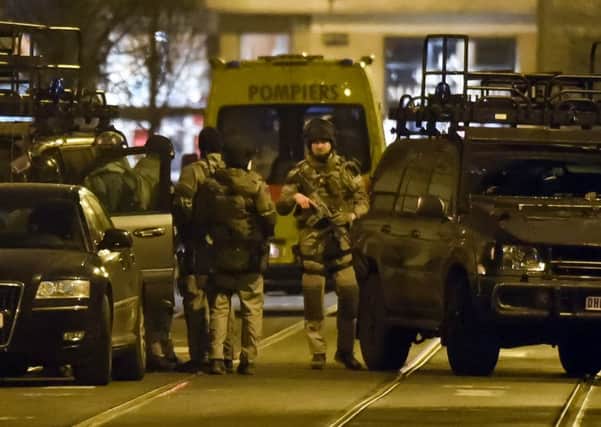 Special operations police take positions during a raid in Brussels  today linked to last year's Paris attacks.