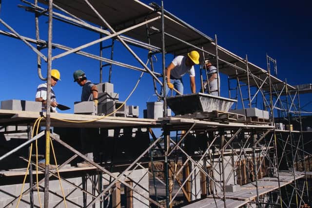 Construction Workers Building with Cinder Block --- Image by Â© Royalty-Free/Corbis