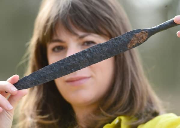 Map Archaeological Practice Ltd staff member Sophie Coy holds a spear head that was found at a 2,500-year-old settlement discovered in Pocklington