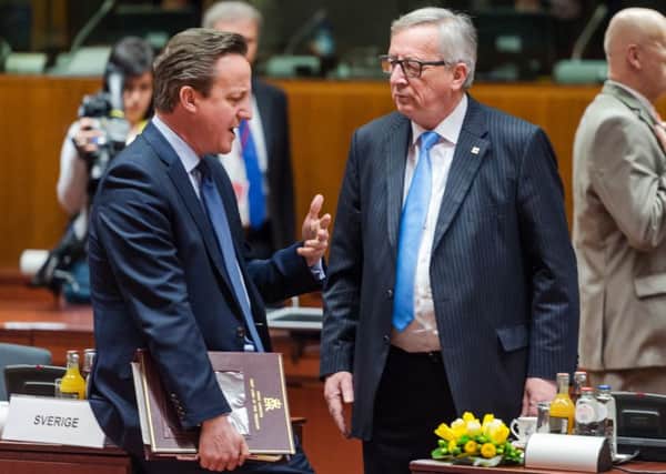 British Prime Minister David Cameron, left, speaks with European Commission President Jean-Claude Juncker during a round table meeting at the EU summit on the migration crisis.