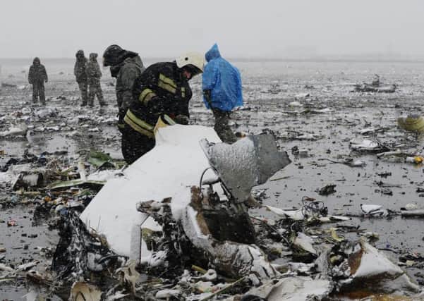 Russian Emergency Ministry employees investigate the wreckage of a crashed plane at the Rostov-on-Don airport, about 950 kilometers south of Moscow, Russia. A Dubai airliner crashed and caught fire early Saturday while landing in strong winds in the southern Russian city of Rostov-on-Don, officials said. (AP Photo)
